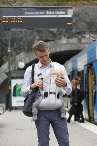 Man using a BabyBjorn carrier for his baby.