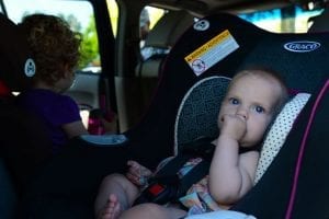 Little boy sitting on the convertible car seat while enjoying his best ride. His brother is also on his convertible car seat. 