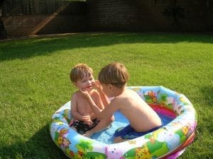 Two kids playing in mini pool.
