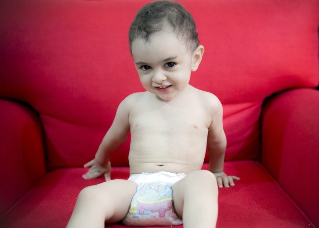 A cute baby in a diaper is ready to play.