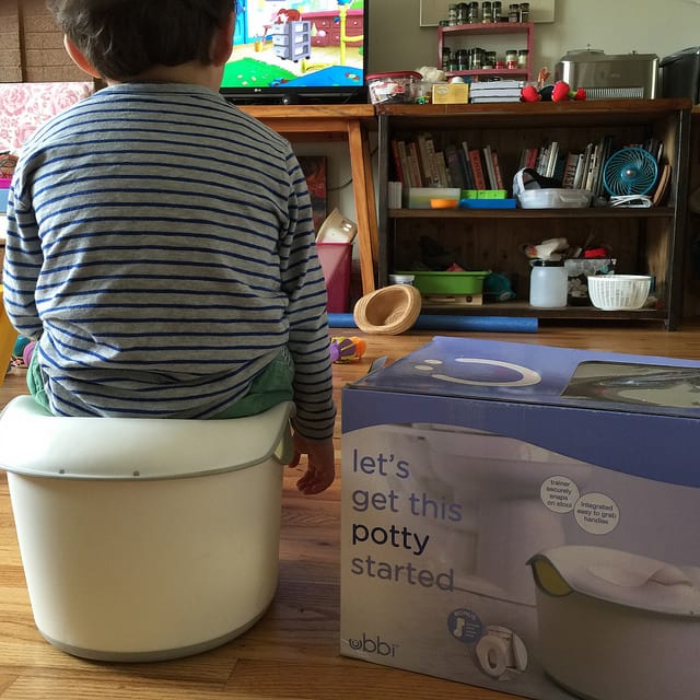 A toddler sitting on a potty.