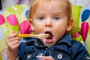 Baby eating alone.