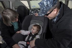 parents buckling their baby's car seat