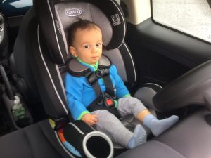 A child sitting in a Graco booster