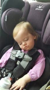 The toddler is sleeping comfortably in a Diono car seat