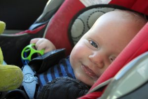 Baby smiles to mom while using Chicco seat. 