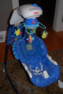 Colored swing, secured with sturdy straps for safety. The swing is suspended from a sturdy frame, and the child's face is lit up with pure delight as they experience the simple pleasure of swinging.