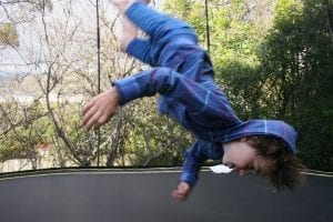 boy having the time of his life jumping on a propel trampoline.