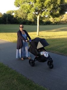 A mom strolling with her baby in their jogging pram