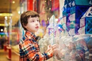 A child, age 4 , looks on in amazement at a display, evoking the magic found in the best books for his year group.