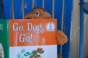 A stuffed toy dog peers out from behind the children's book 'Go, Dog. Go!' - a classic for encouraging reading for kids in younger years.