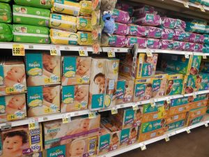 Diapers. There is a stack of diapers on the shelf. There are differeny brands to choose from. Each brand has a unique specifications that can help all mothers out there.
