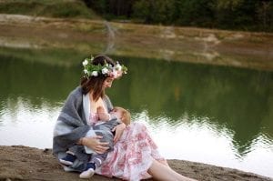 A mother feeding her child next to the river