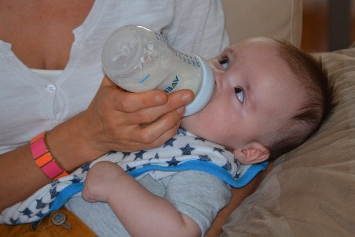 A baby being fed formula from a bottle