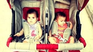 Two kids rides the double stroller outdoors while experiencing the best comfort during the ride.