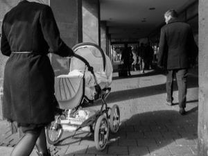 A woman pushing one of the best strollers in the old time, quality baby carriage that is developed from time to time