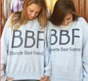 Friends, one blonde and the other brunette, wearing matching clothes