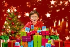 A happy male kid surrounded by so many gifts for 9 year old kids