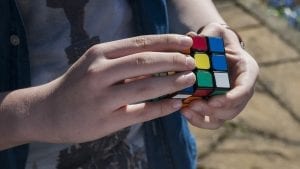 A kid playing rubiks cube
