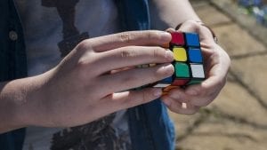 A 9 year-old male kid playing rubiks cube- one of the best gifts for fun