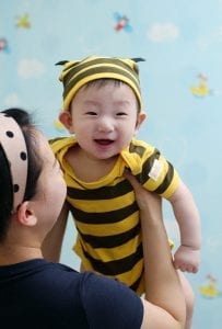 A mom holding baby wearing a Best Friend Onesie, also known as a baby bodysuit.
