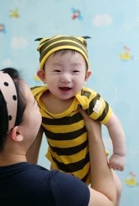 A mom holding the baby wearing a best friend onesie