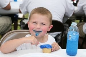 A healthy child eating a cupcake. This keeps him happy