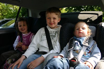 kids sitting on their baby car seat at the back part of the car