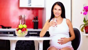 a pregnant woman drinking water
