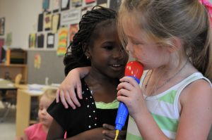 two girls singing with a microphone