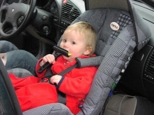 A baby sitting comfortably on a nice car seat