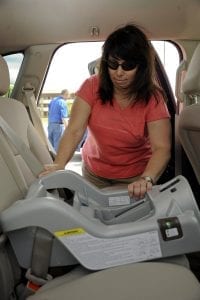A mom installing a carseat.