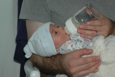 A father feeding his newborn baby with best formula through a baby bottle. 