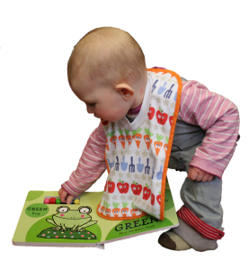 a little baby playing with sensory reading books while wearing a bib.