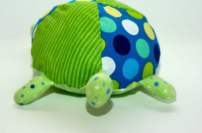 Lifesize stuffed toy turtle with large colorful circles. The shell of the lifesize turtle has polka dot and stripe design. The head of the lifesize stuffed turtle doesn't have a face tho.