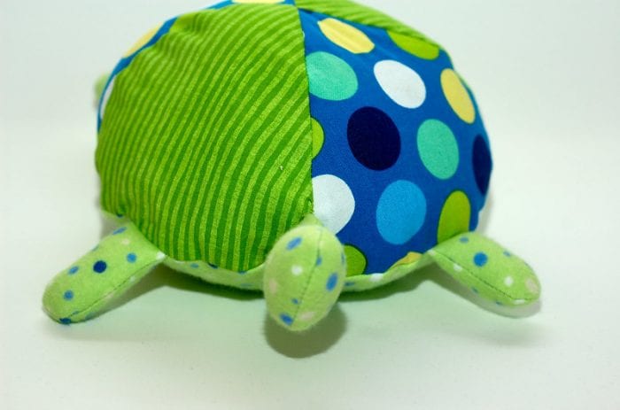 Lifesize stuffed toy turtle with large colorful circles. The shell of the lifesize turtle has polka dot and stripe design. The head of the lifesize stuffed turtle doesn't have a face tho. 