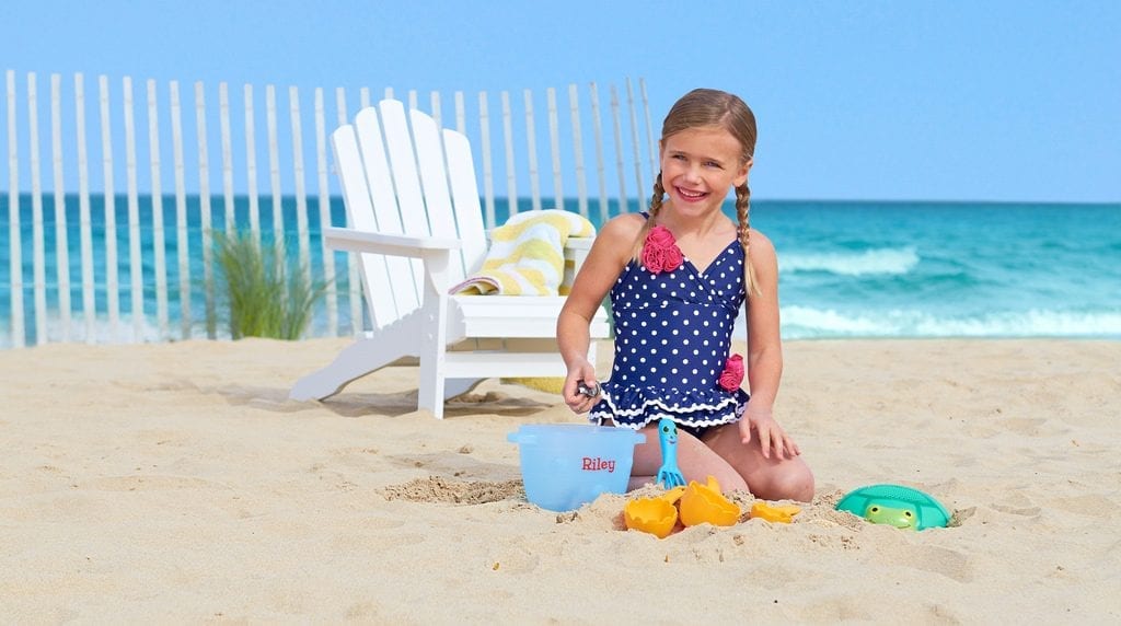 A girl playing one of best beach sand castle toys.