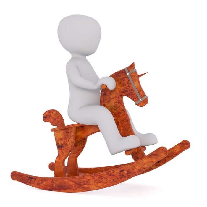 A figure of a little boy riding a brown rocking horse