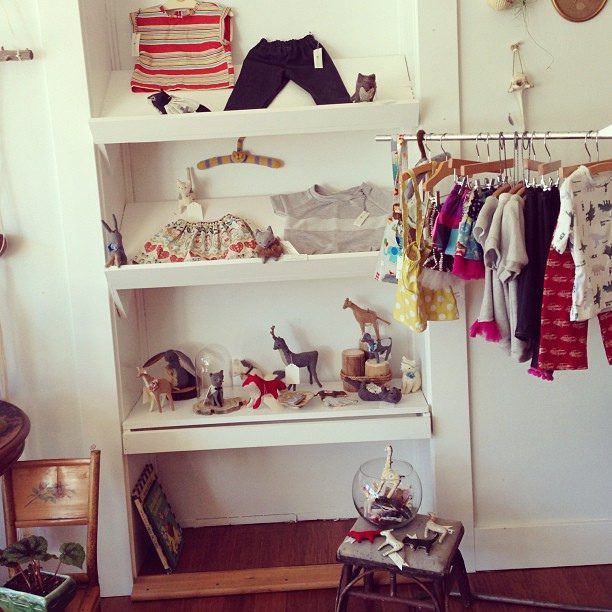 A Baby's room with different baby's clothes hanged on baby hangers with clips. These clothes rods help organize the baby's closets and things.