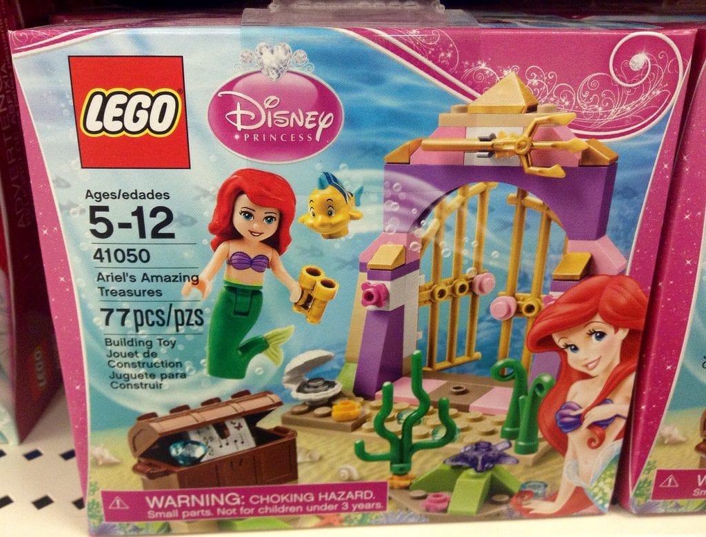 A LEGO Disney Princess playset box, featuring Ariel from "The Little Mermaid" with a treasure chest, a golden gate, and Flounder, designed ages 5-12.