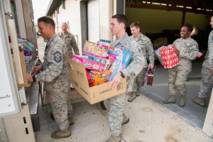 Diverse militaries carrying baby doll toys and other play essentials, showcasing a heartwarming blend of duty and nurturing moments.