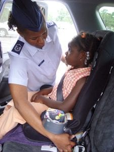 The mother is teaching her child how to use a booster seat.