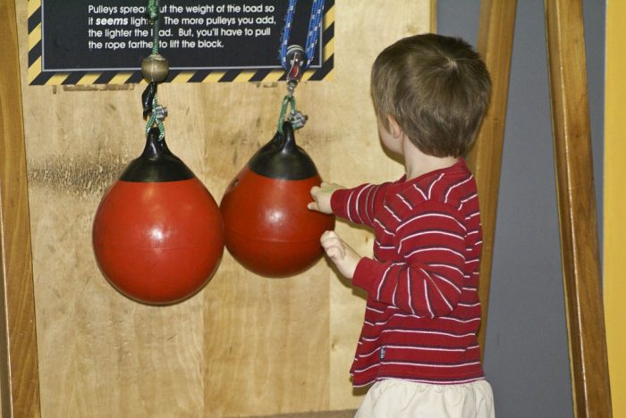 A boy punches the kids punching bag. 