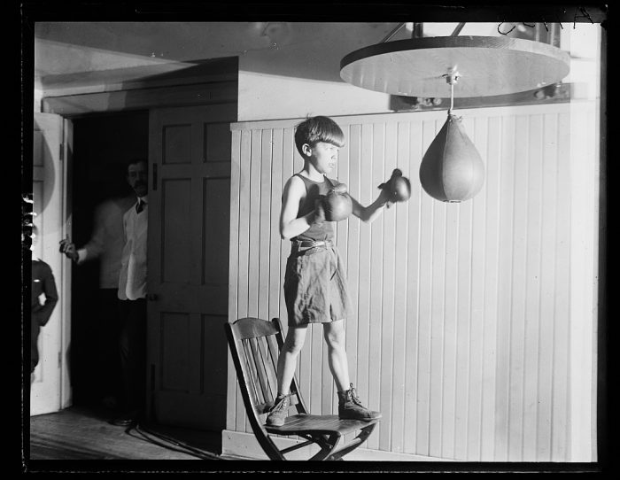 A boy hits the kids punching bag.