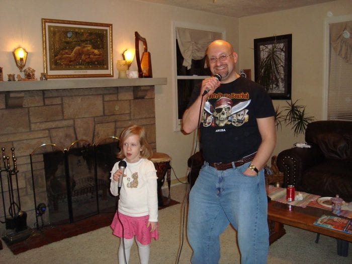 A father and his daughter share a special bonding moment through the joy of singing together. 