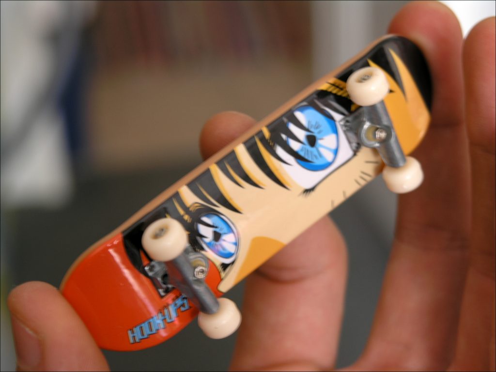 A close-up photo of a miniature skateboard, commonly known as a "tech deck"