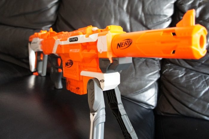 An orange-body automatic Nerf gun with a gray handle.