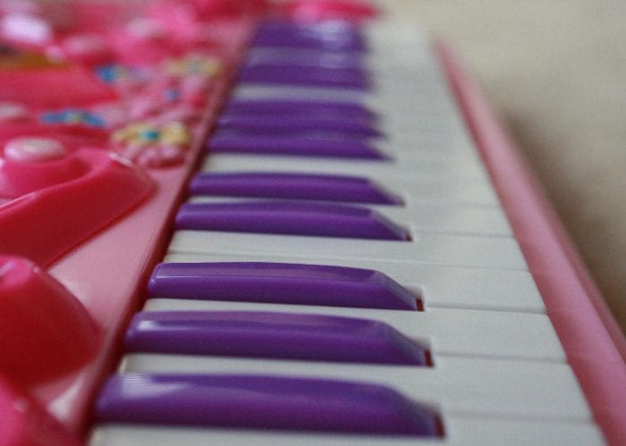 A toy piano with white and purple keys.