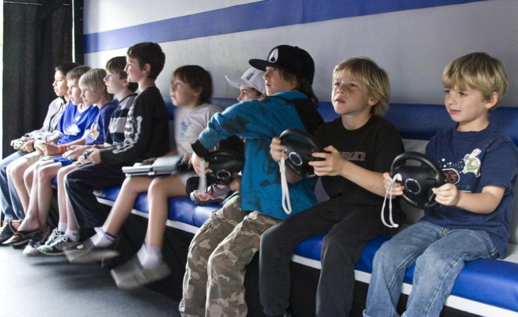 Boy with age 12 years old and below are playing video games. What could be the best gift for 12 year old boy? A group of playing children. They are around the age of twelve.