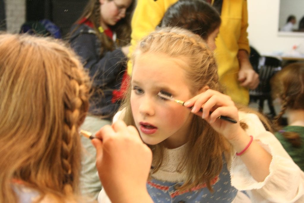 child practicing beauty tricks